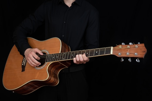 Un homme joue d'une guitare électro-acoustique