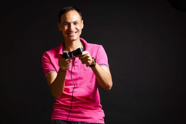 un homme joue avec un joystick à la maison sur fond noir