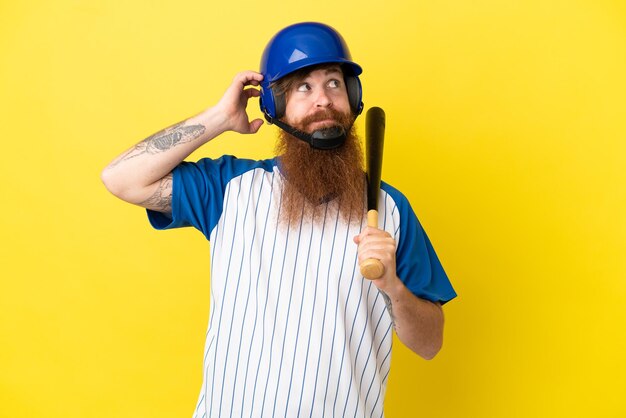 Homme de joueur de baseball rousse avec casque et batte isolé sur fond jaune ayant des doutes