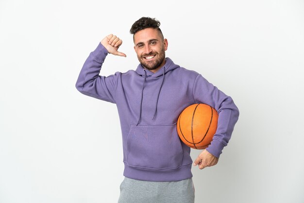 Homme de joueur de basket-ball isolé sur un mur blanc fier et satisfait de soi