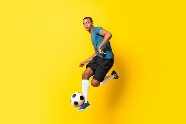 Homme de joueur de football afro-américain sur jaune isolé