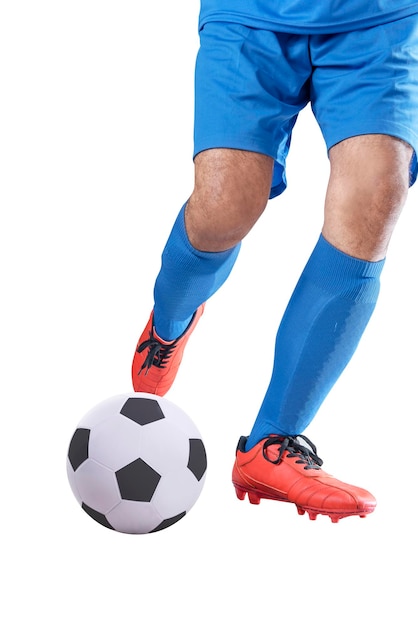 Homme de joueur de football dans un maillot bleu donnant un coup de pied dans le ballon