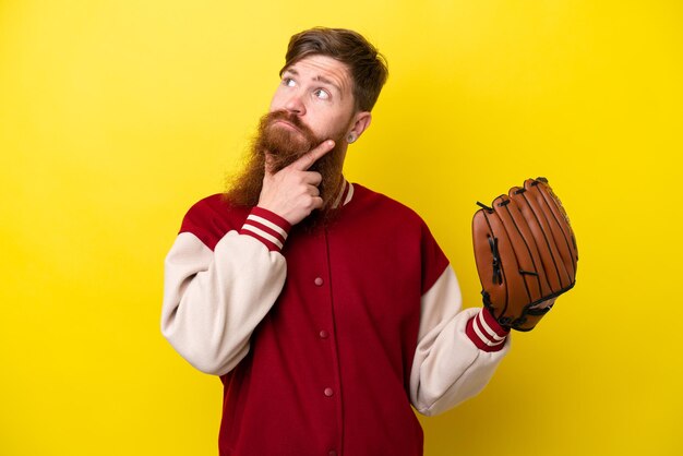 Homme joueur rousse avec barbe avec gant de baseball isolé sur fond jaune ayant des doutes