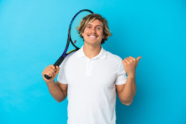 Homme de joueur de tennis blonde isolé pointant vers le côté pour présenter un produit