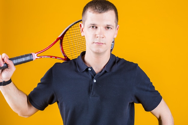 Homme de joueur de tennis professionnel sur un mur jaune vif