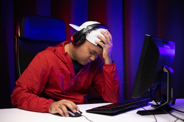 Photo homme de joueur de tristesse jouer à l'ordinateur pc. il perd dans le match. a raté la chance de devenir champion en tournoi. jeune indien jouant au jeu vidéo en ligne à la maison.