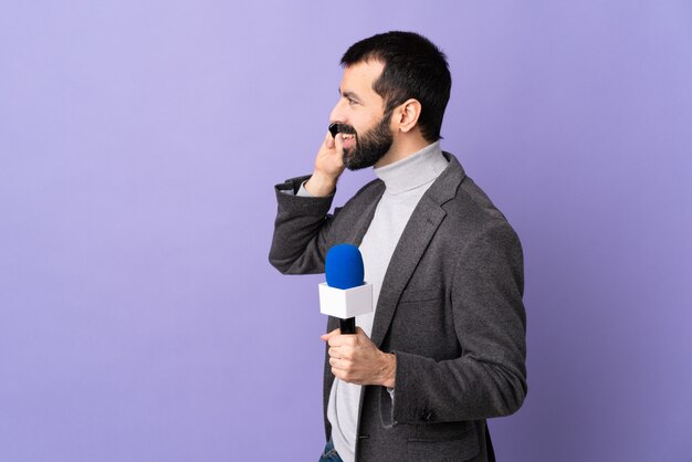 Photo homme jounaliste sur fond violet isolé