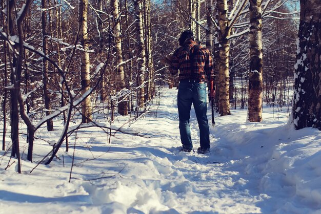 Homme de jour de dimanche avec la hache dans la forêt