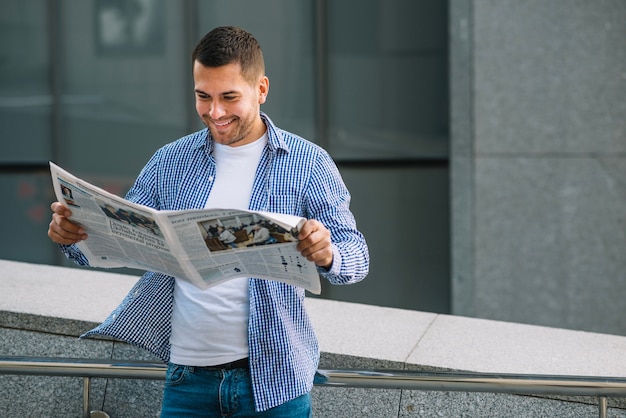 Photo homme avec journal s'appuyant sur la rampe