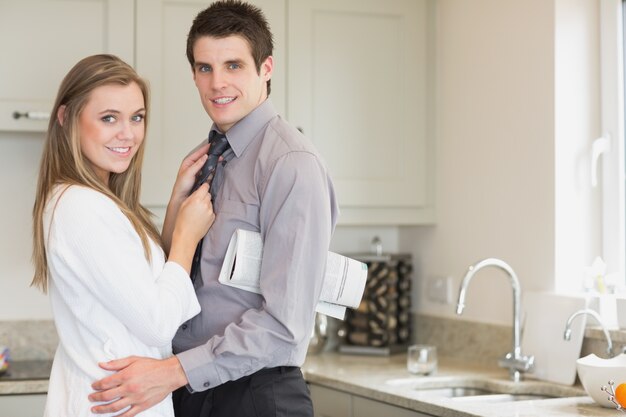 Homme avec un journal sous le bras, serrant sa femme