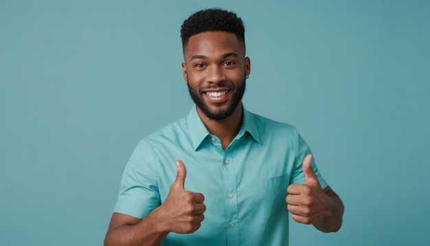 Un homme joyeux dans une chemise teal donne un pouce vers le haut son sourire chaud et accueillant contre un teal