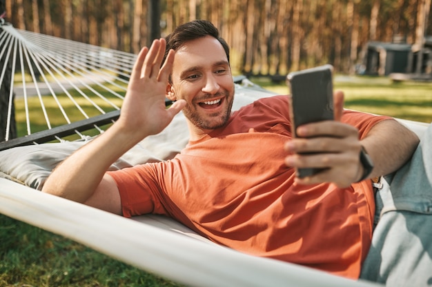 Homme joyeux regardant l'écran du smartphone