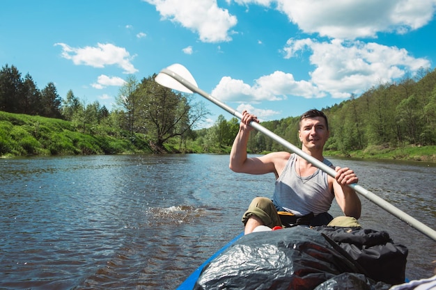 Homme en kayak bateau à rames sur la rivière une randonnée aquatique une aventure estivale Tourisme écologique et extrême mode de vie actif et sain