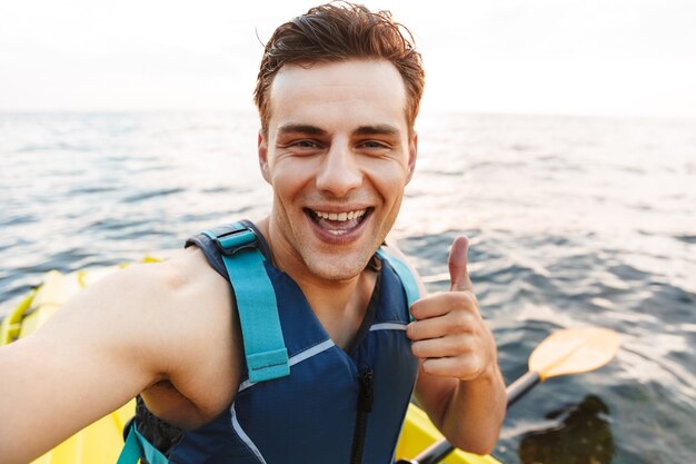 homme kayak sur la mer du lac en bateau faire selfie par caméra.