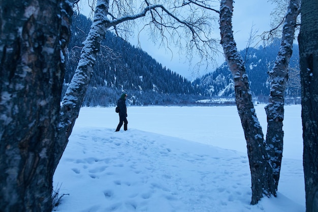 Homme sur le lac de montagne gelé