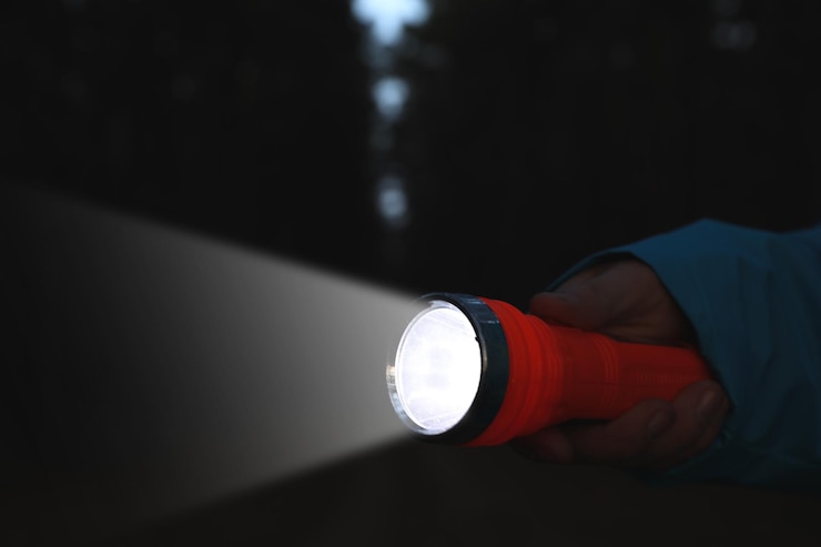 Photo homme avec une lampe de poche lumineuse en gros plan de nuit