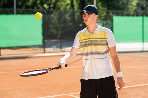 Homme lançant une balle de tennis sur la raquette