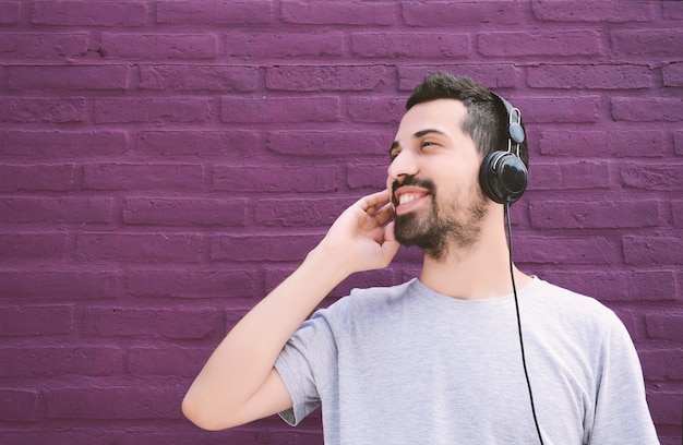 Homme latin écoutant de la musique avec des écouteurs.