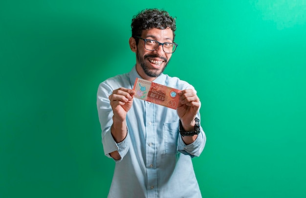 Homme latin isolé une facture d'argent mec heureux avec une facture de 500 cordobas une facture de 500 cordobas