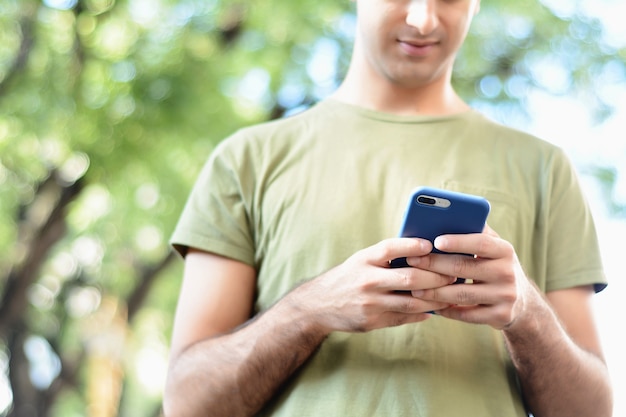 Homme latin tapant sur son téléphone.