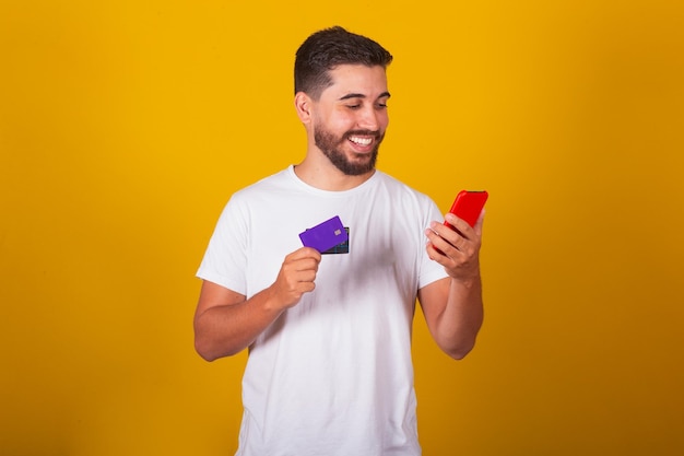 Homme Latino-américain Brésilien Jouant Par Son Téléphone Portable En Utilisant Le Concept D'achat En Ligne Par Carte De Crédit