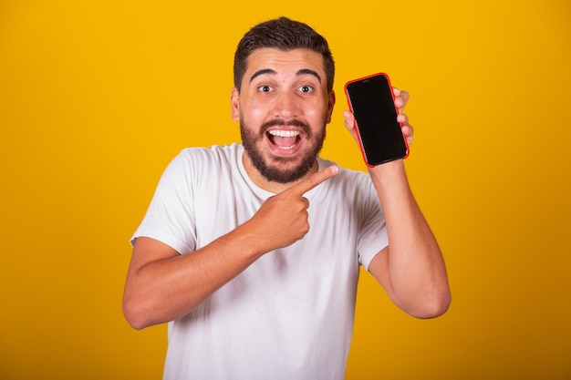 Homme latino-américain brésilien avec la main pointant vers l'écran du téléphone portable pour la communication de l'application