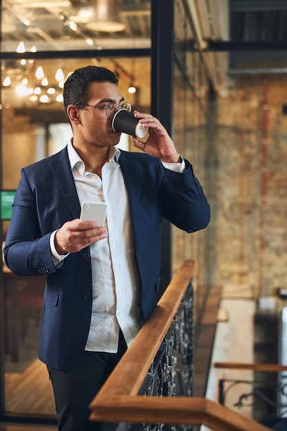 Homme latino-américain en sirotant une boisson chaude