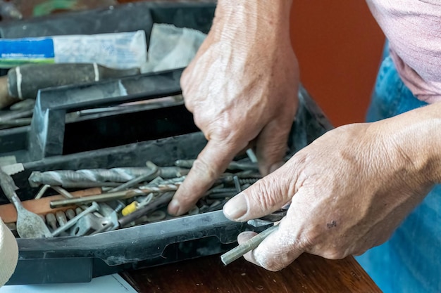 Homme latino à la recherche d'outils dans sa boîte à outils hispanique avec tournevis à la main