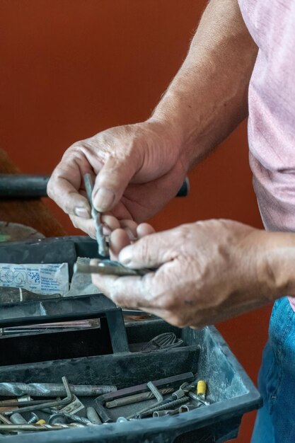 Homme latino à la recherche d'outils dans sa boîte à outils hispanique avec tournevis à la main