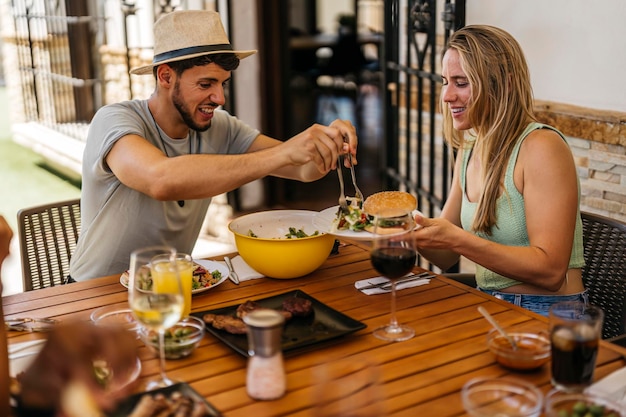 Un homme latino en sombrero jette de la salade comme un hamburger à une femme blanche blonde