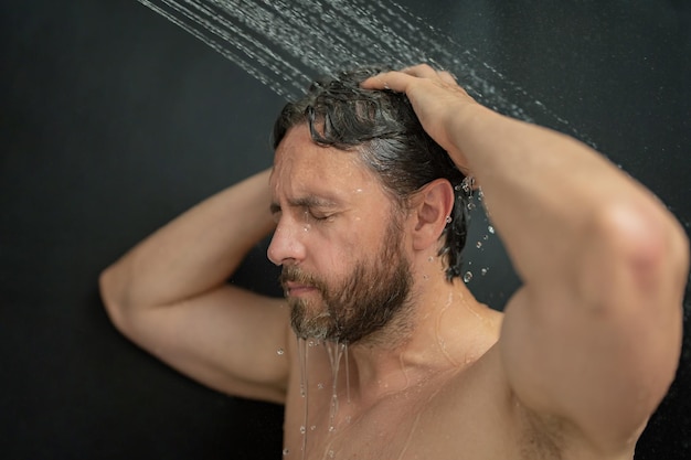 Homme lavant ses cheveux en gros plan portrait homme se baignant sous la douche se lavant les cheveux la tête dans la salle de bain modèle masculin
