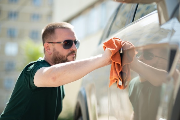 Homme lavant une voiture avec une éponge