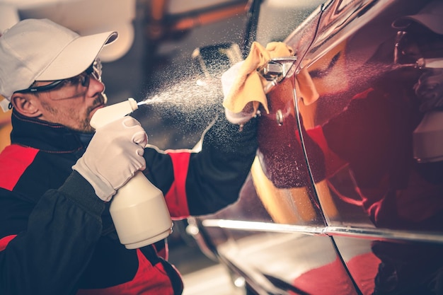 Photo un homme lave une voiture au garage.