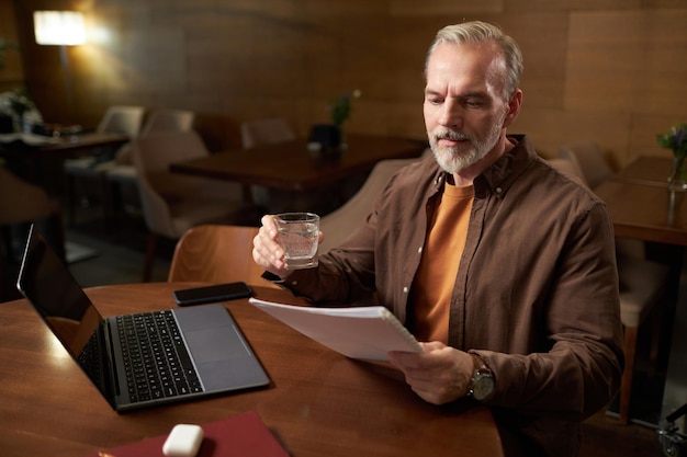 Homme lisant un contrat assis dans un café