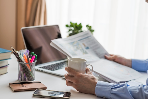 Photo homme lisant un journal au bureau