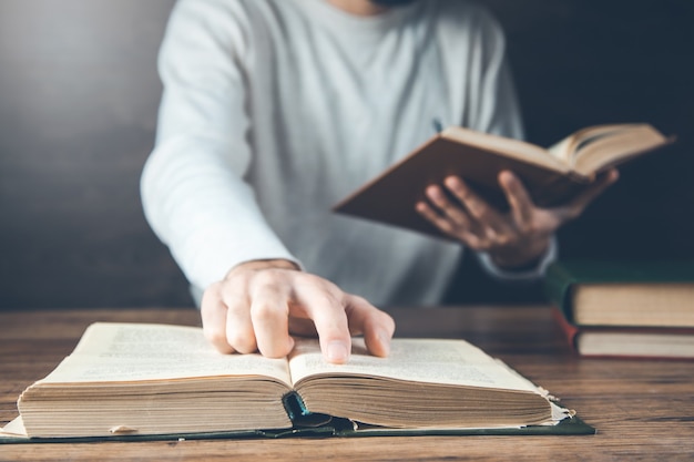 Homme lisant un livre sur le bureau en bois