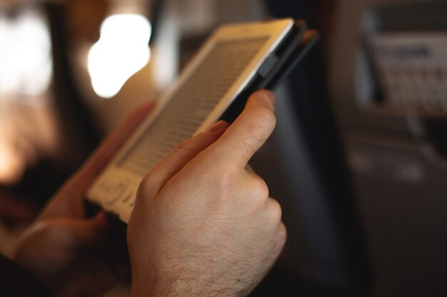 Homme lisant un livre électronique dans un avion