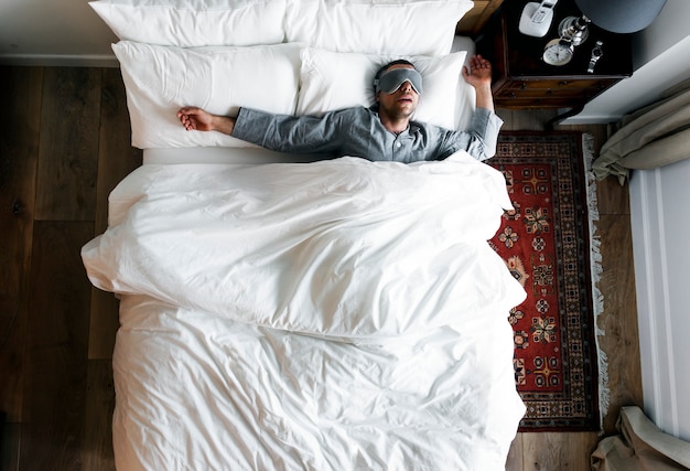 Homme Sur Le Lit Dormir Avec Une Couverture Pour Les Yeux