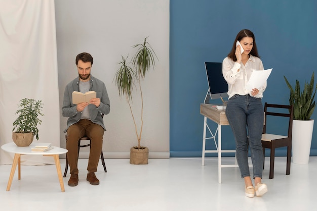 Photo l'homme lit pendant que la femme parle sur mobile