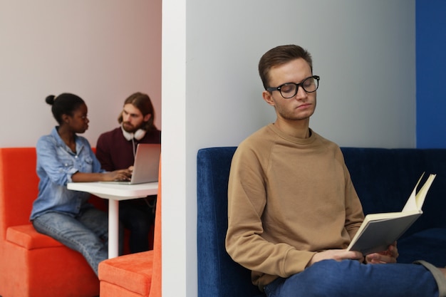 Homme avec livre dans la salle d'attente