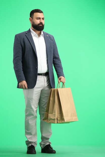 Un homme de longueur sur un fond vert avec des sacs