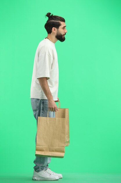 Un homme de longueur sur un fond vert avec des sacs