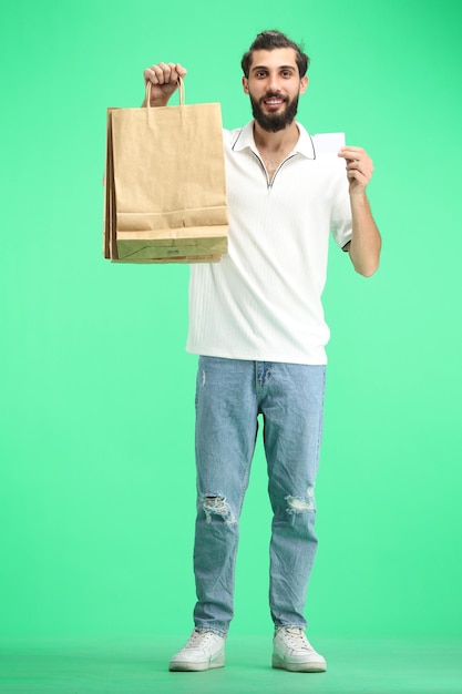 Un homme de longueur sur un fond vert avec des sacs