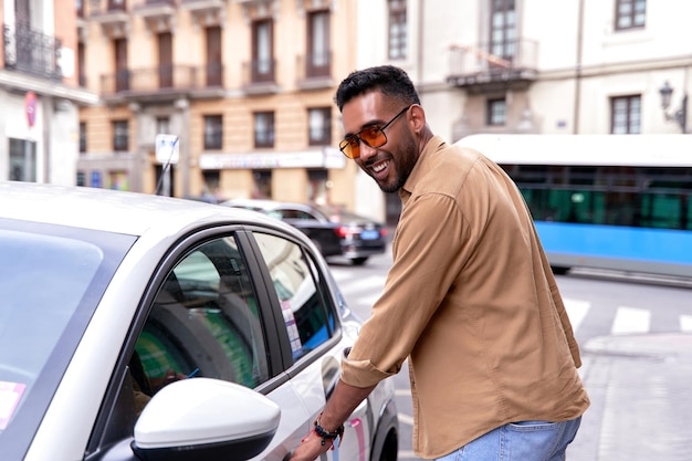 Homme louant une voiture via une application mobile covoiturage location de voiture à l'heure transport dans la ville