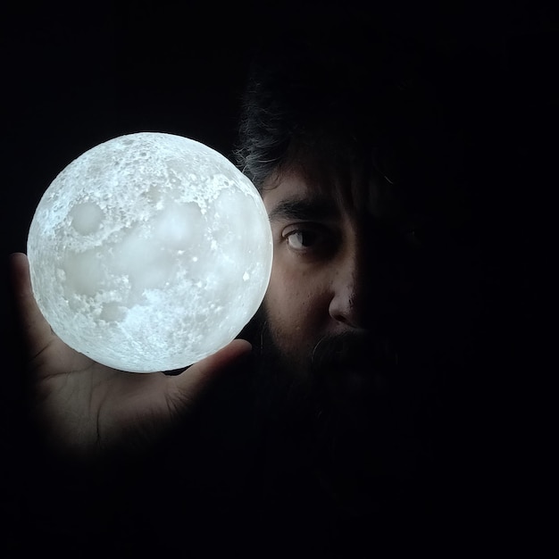 Photo l'homme avec la lune dans les mains conquiert l'espace