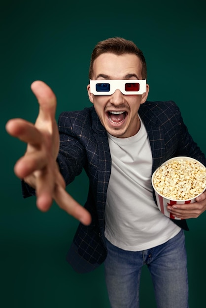 Photo un homme en lunettes 3d tenant un grand seau de pop-corn