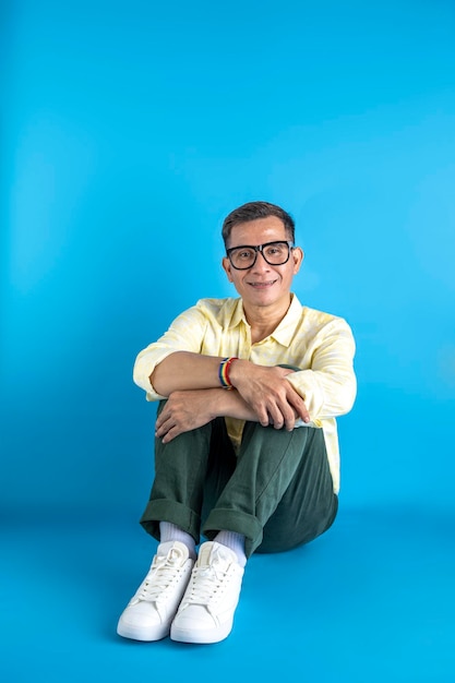 Homme avec des lunettes et une chemise portant un bracelet arc-en-ciel