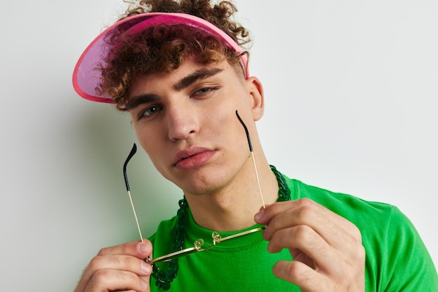 Homme à lunettes colorées posant sur blanc