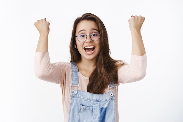 homme à lunettes criant oui en soutien et en étonnement comme se sentant joyeux de gagner un but ou de gagner en levant les poings fermés pour célébrer le triomphe.