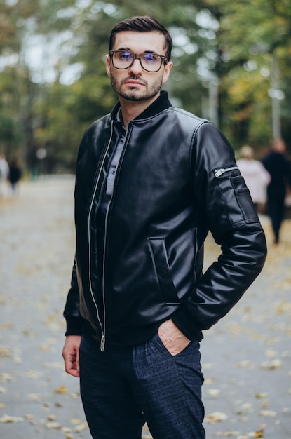 un homme avec des lunettes dans une veste en cuir